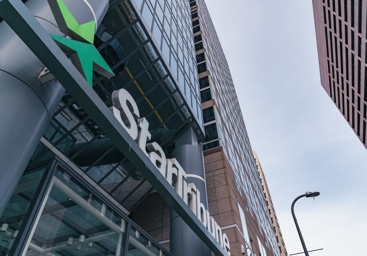 A photo of the Star Tribune office angled toward the logo.