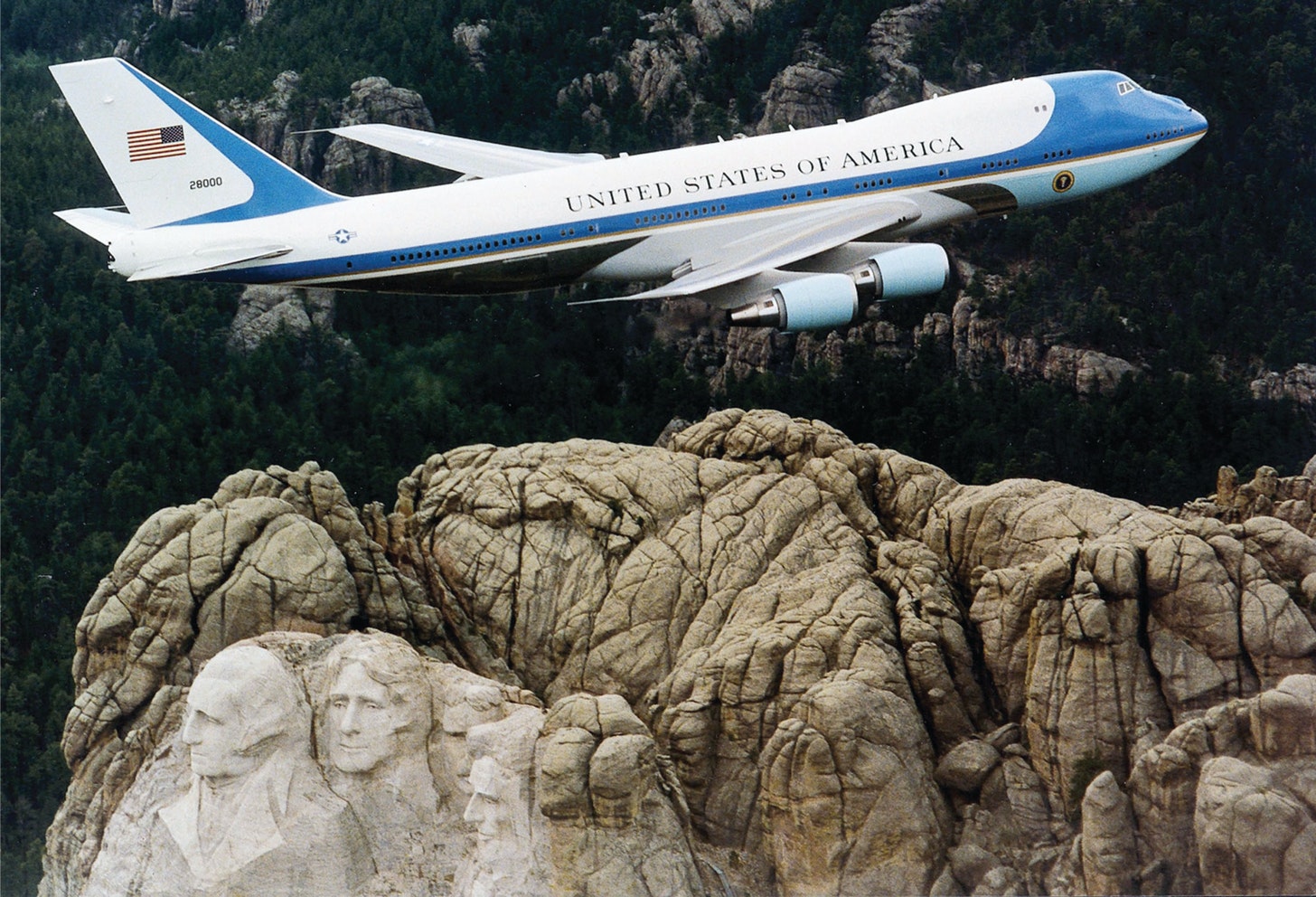 An image of a plane with United States of America written over it flying over Mount Rushmore.