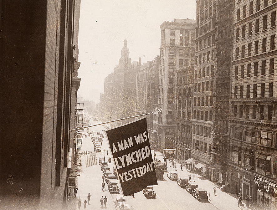 A flag that reads "A man was lynched yesterday" hangs from the window of the NAACP headquarters on 69 Fifth Ave., New York City.