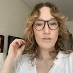 The author wears glasses and a white button-up, looking straight into the camera.