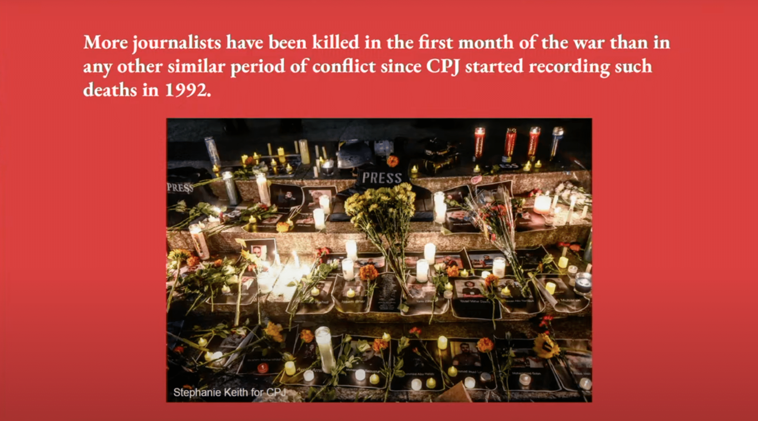 A red slide from a presentation that reads "More journalists have been killed in the first month of the war than in any other similar period of conflict since CPJ started recording such deaths in 1992." A photo of graves for journalists with flowers, candles, and their photos is under the text.